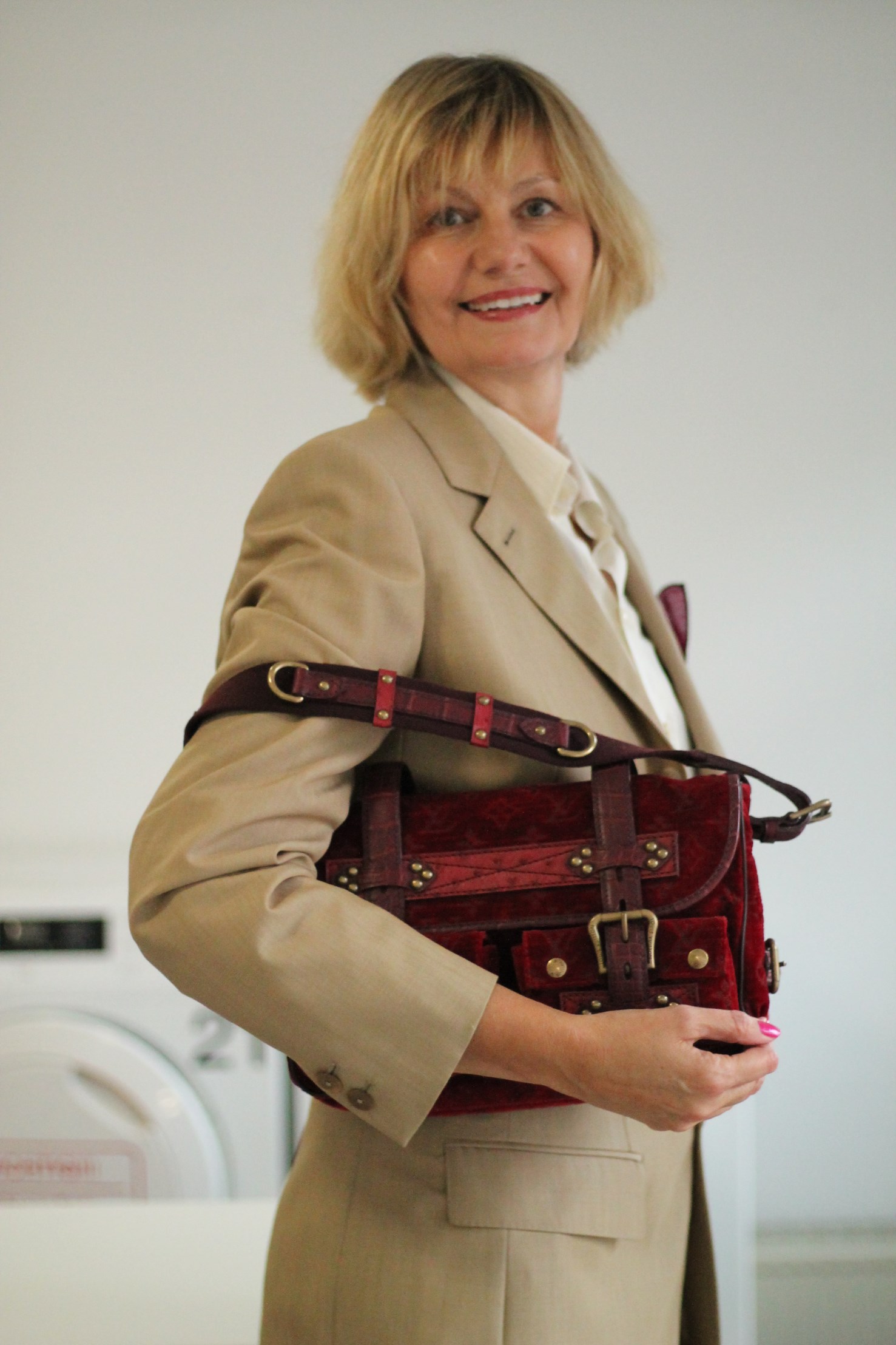 frau ueber 50 im sylter waschsalon mit vuitton handtasche aus samt